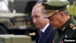 Russia -- Russian President Vladimir Putin (L) and Defense Minister Sergei Shoigu arrive for the opening of the Army-2015 International Military-Technical Forum in Kubinka, outside Moscow, June 16, 2015