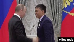 Rossiya prezidenti Vladimir Putin Kremlda Marat Isaevga medal topshirmoqda.