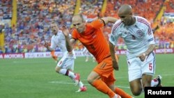 Danimarkalı Simon Poulsen (Sağda) və Hollandiyalı Arjen Robben top uğrunda mübarizədə