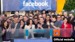 Facebook-тың бас директоры Марк Цукерберг (ортада) Nasdaq биржасына әлеуметтік желінің акциясын шығарды. (Көрнекі сурет)