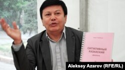 Қанат Тасыбеков алғашқы оқулығын - «Ситуативный казахский» кітабын таныстырып отыр. Алматы, 16 тамыз 2014 жыл.