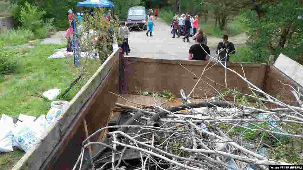 Белсенділер ағаштың қураған бұтағы, шлангі қиығы тәрізді үлкенірек заттарды саябақ шаруашылығы бөлген жүк көлігіне тиеді.