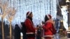 KAZAKHSTAN -- People dressed as Santa Claus stay next to the Christmas illuminations in Almaty, Kazakhstan December 20, 2018